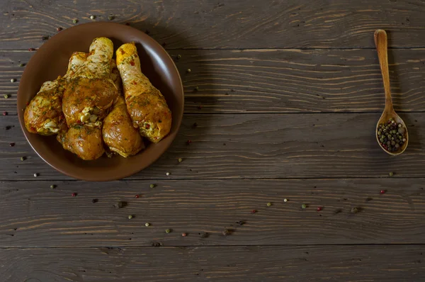 Yukarıdan görüntüleyin. Çiğ tavuk budu baharat yalan bir tepside ile kaplı. Arka plan. Biber