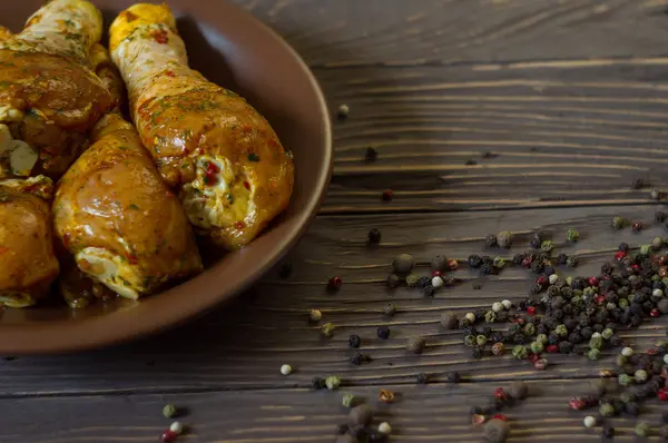 Çiğ tavuk budu baharat yalan bir tepside ile kaplı. Arka plan. Ufalanmış biber renk.