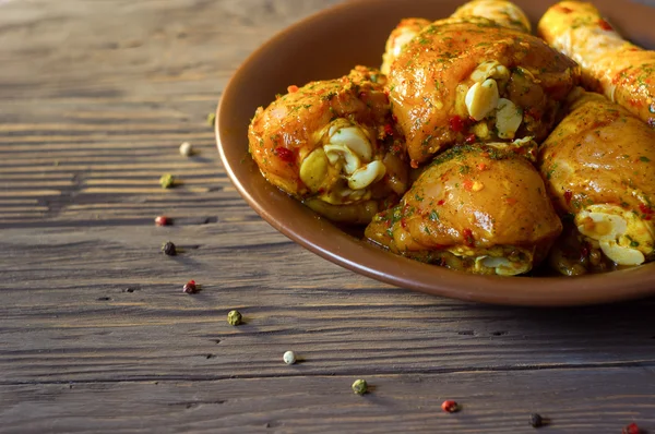 Çiğ tavuk budu baharat yalan bir tepside ile kaplı. Arka plan. Biber renk