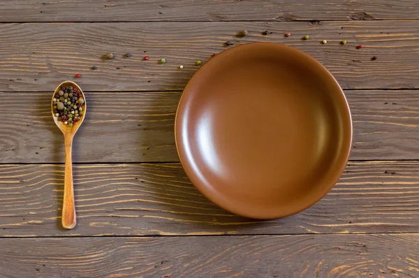 Renkli biber tahta kaşıkla yanındaki boş levha kurullarında yatıyor