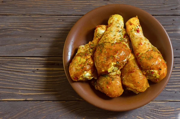 Piernas de pollo crudas cubiertas con especias yacen en un platter.Background — Foto de Stock