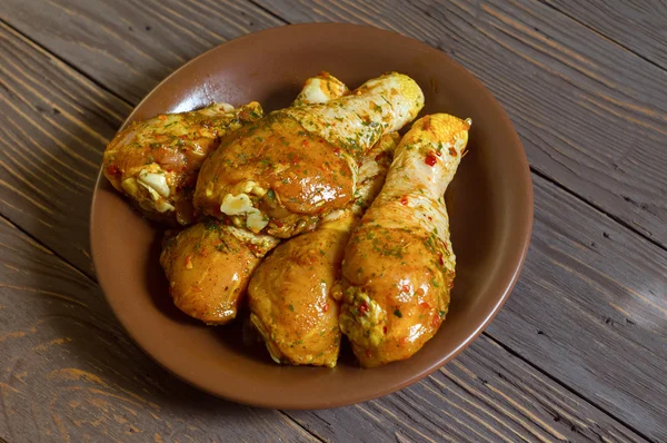 Baharat yalan bir tepside kaplı çiğ tavuk budu