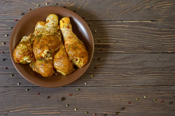 Yukarıdan görüntüleyin. Çiğ tavuk budu baharat yalan bir tepside ile kaplı. Arka plan. Biber renk.