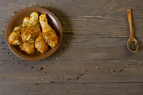 Yukarıdan görüntüleyin. Çiğ tavuk budu baharat yalan bir tepside ile kaplı. Arka plan. Biber