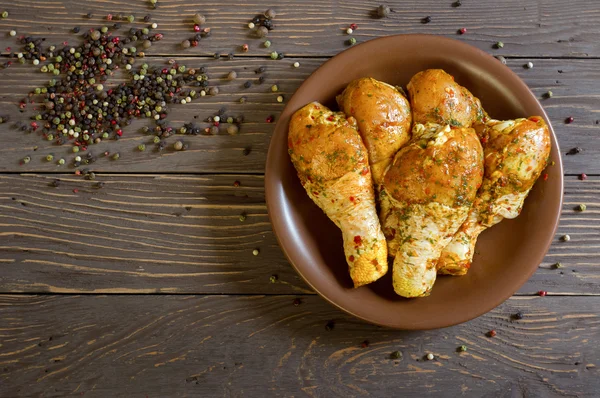 Çiğ tavuk budu baharat yalan bir tepside ile kaplı. Arka plan. Ufalanmış biber renk. Yukarıdan görüntülemek