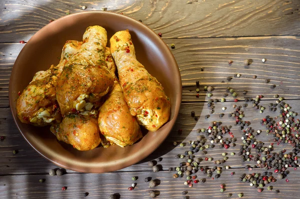 Arka plan. Çiğ tavuk budu baharat yalan bir tepside ile kaplı. Arka plan. Ufalanmış biber renk. Yukarıdan görüntülemek