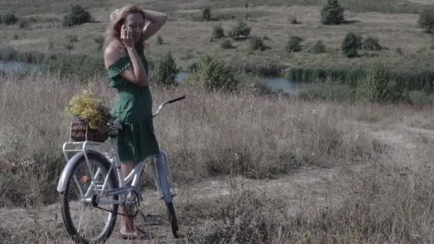 Fiatal nő a kerékpáros az úton, beszél a telefonon — Stock videók