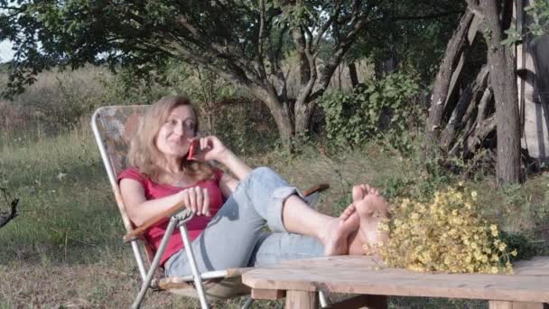 Mujer joven haciendo llamada telefónica al aire libre en verano — Vídeos de Stock