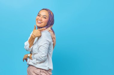 Güzel Asyalı kadın gülümsüyor ve boşluğu işaret ediyor.