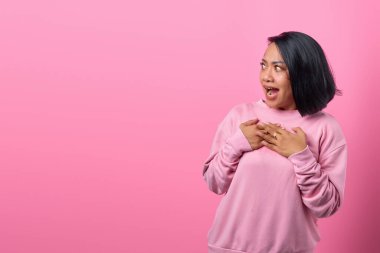 Asyalı kadın şok oldu ve şaşırdı. Pembe arka planda boş bir alan gördü.