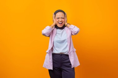 Sarı arka planda kulaklarını kapatarak gülen bir iş kadınının portresi