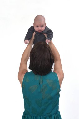 Beyaz arka planda bebeği kaldıran bir annenin dikiz görüntüsü