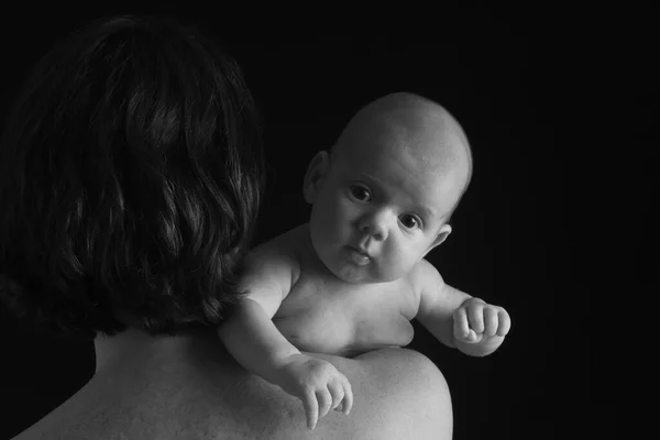 mother holding her son on black background