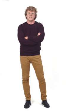 Bir adamın tam portresi, kıvırcık saçlı, beyaz arkaplan, kollarını kavuşturmuş.,