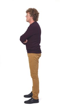 Bir adamın tam portresi, kıvırcık saçlı, beyaz arkaplan, kollarını kavuşturmuş.