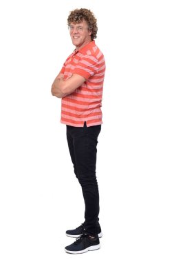 Bir adamın tam portresi, kıvırcık saçlı, beyaz arkaplan, kamera ve kollar çapraz.