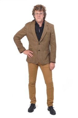 Beyaz arka planda bir adamın tam portresi, eller kalçada.