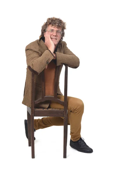 白人を背景に椅子に座っているブレザーを持つ中年男性の正面図 — ストック写真