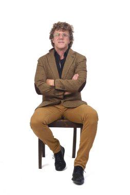 Beyaz arka planda sandalyede oturan ceketli orta yaşlı bir adamın ön görüntüsü, 