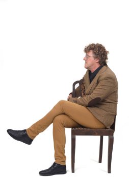 Beyaz arka planda sandalyede oturan ceketli orta yaşlı adamın yan görünüşü, 