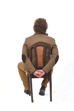 Beyaz arka planda sandalyede oturan ceketli orta yaşlı bir adamın dikiz aynası.