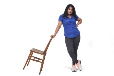 Beyaz arka planda sandalyeyle oynayan kadın