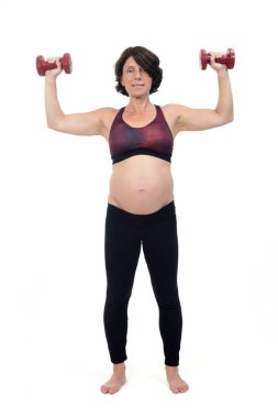 Hamile kadın beyaz arka planda dambıl egzersizi yapıyor.