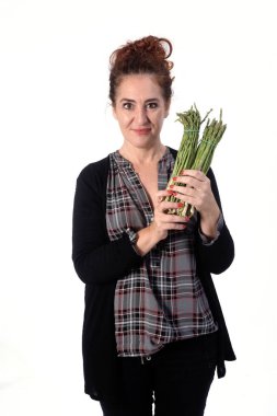 Beyaz arka planda aspargus olan bir kadının portresi.
