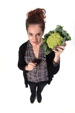 Beyaz arka planda brokoli olan bir kadının portresi.