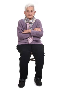 Koltukta oturan yaşlı kadının ön görüntüsü arka planda çaprazlanmış.