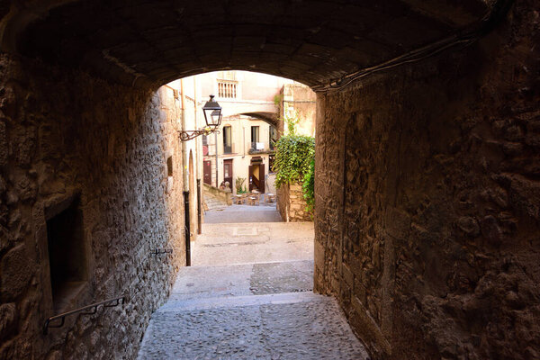 Arch in the street of Pujada de Sant Domenech, Agullana Palace in the background olt town of Girona, Catalonia, Spain