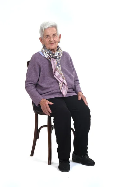 坐在白色背景的椅子上的老年妇女的照片 — 图库照片