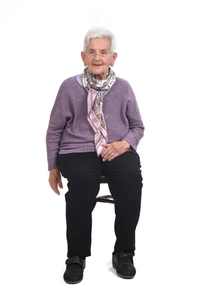 Framsidan Senior Kvinna Sitter Stol Och Ler Whte Bakgrund — Stockfoto
