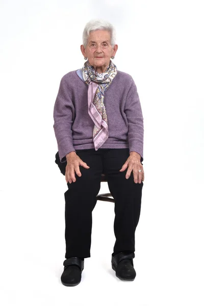 白い背景に椅子に座っている先輩女性の正面図 — ストック写真
