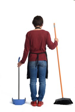 Beyaz arka planda süpürge ve faraş olan bir ev kadınının arka görünüşü