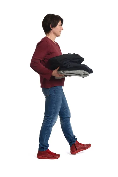 Vista Lateral Uma Mulher Andando Segurando Uma Pilha Roupas Limpas — Fotografia de Stock