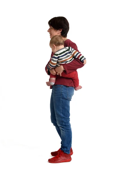 Beyaz Arka Planda Bebeğini Taşıyan Bir Annenin Yan Görüntüsü — Stok fotoğraf