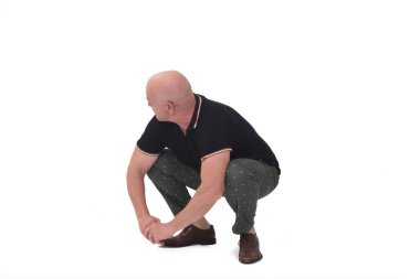Adam başka tarafa bakıyor ve beyaz arka planda oturuyor.