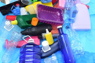Mavi plastik poşetlerde bir grup plastik kap.