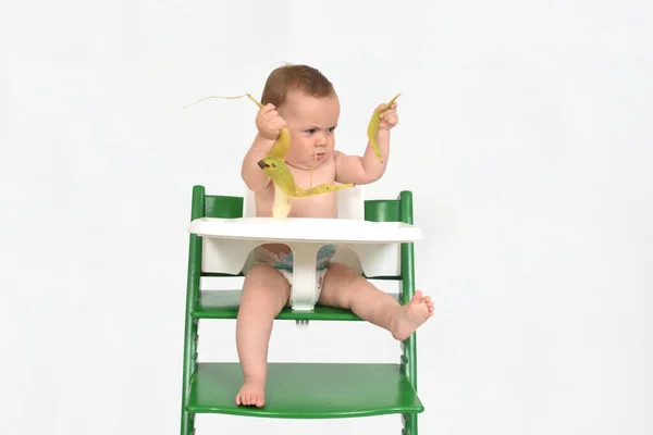 baby playing with banana on white background