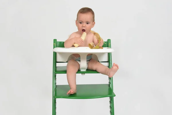 Niño Comiendo Plátano Sentado Una Trona Sobre Fondo Blanco —  Fotos de Stock