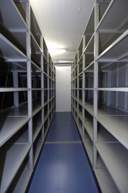 Her iki duvarda raflar bulunan boş bir depolama ünitesi -