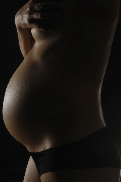 Těhotná s černým pozadím — Stock fotografie