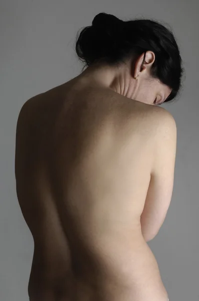Голая женщина с болью в спине — стоковое фото