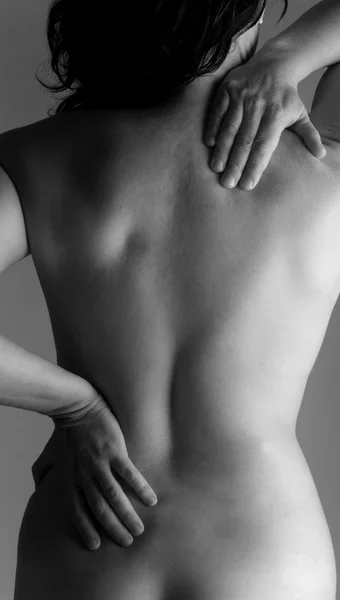 Donna nuda con mal di schiena — Foto Stock