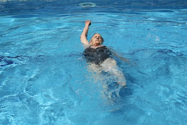 Starší žena zábava v bazénu — Stock fotografie