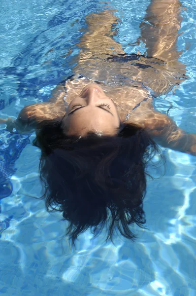 Mulher relaxante em uma piscina — Fotografia de Stock