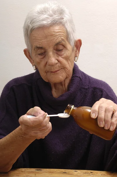 Senior vrouw nemen siroop — Stockfoto