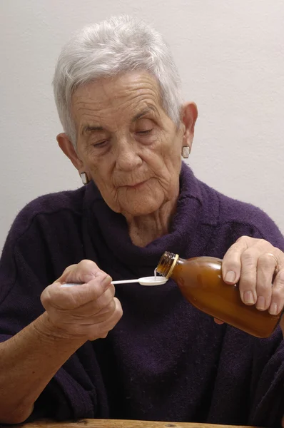 Mujer mayor tomando jarabe — Foto de Stock