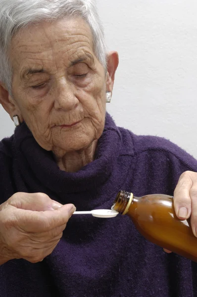 Mujer mayor tomando jarabe — Foto de Stock